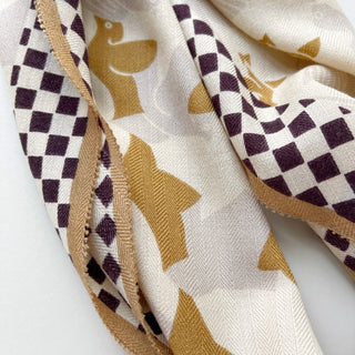 Beige cashmere silk scarf with Art Deco bird motifs in golden brown, featuring a deep brown and cream checkerboard border pattern