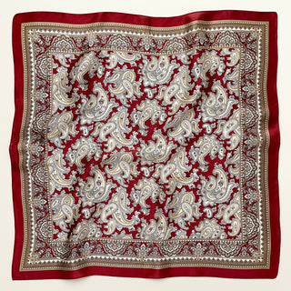 Dark red silk neckerchief with intricate beige and white paisley pattern, featuring decorative border with geometric details on luxurious fabric