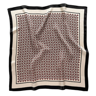 Square silk bandana scarf with repeating red geometric pattern on cream background, bordered by elegant black trim, displayed flat
