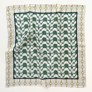 Small square silk scarf with teal green zigzag pattern center, surrounded by white border with gold diamond geometric design and hand-rolled edges.
