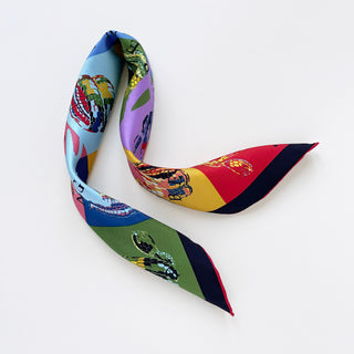 Luxury silk bandana scarf with colorful geometric blocks in blue, red, green, purple, and yellow featuring stylized snake print patterns