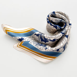 Elegant silk square scarf with blue peony pattern on beige background, featuring blue borders and gold trim, displayed in a softly draped style
