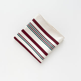 Folded silk scarf with modern striped pattern in burgundy and green on cream background, featuring hand-rolled edges and luxurious twill texture