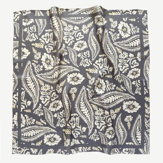 Ash grey silk scarf with elegant cream floral and leaf pattern, featuring hand-rolled edges and delicate yellow accents in a square bandana style