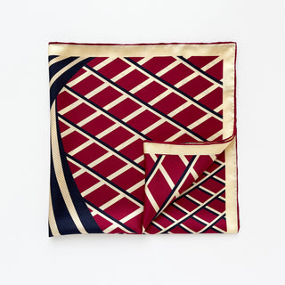 Luxury double-sided silk scarf with geometric pattern featuring red diamonds outlined by navy blue and cream borders, with hand-rolled edges and Kanagawa wave design.