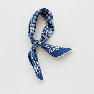 Steel Blue silk scarf with checkered pattern and decorative baroque design, tied in a casual knot against white background