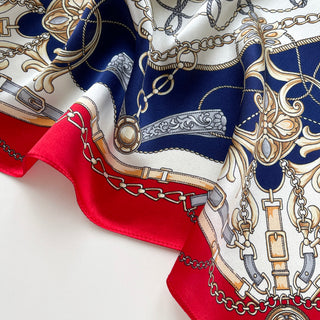 Luxury 53cm silk bandana featuring red and navy baroque bridle design with intricate equestrian chains, buckles, and ornamental patterns on elegant fabric