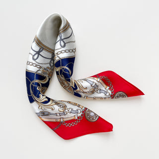 Luxury 53cm silk bandana in red and navy with baroque equestrian design featuring ornamental chains, buckles, and decorative elements on white background