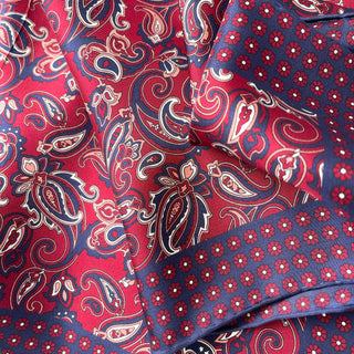 Luxurious silk neckerchief featuring plum red and navy blue patterns with classic paisley design and floral border on premium twill fabric