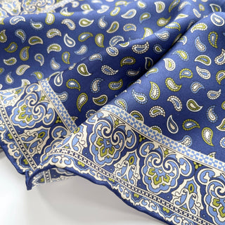 Blue silk neckerchief with small paisley pattern throughout and ornate decorative border featuring floral designs in white, blue and olive green