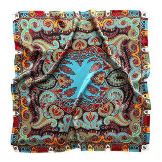Square silk scarf with turquoise background featuring intricate bohemian paisley patterns in vibrant orange, red, and gold with decorative border