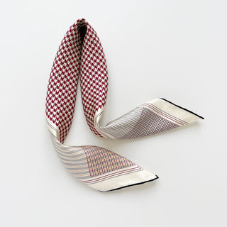 Luxurious red and white houndstooth silk scarf with hand-rolled edges, featuring elegant border patterns on a white background, elegantly draped.