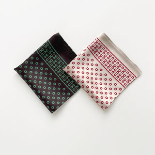 Two silk scarves with horseshoe print patterns - brown with green accents on left and beige with red accents on right, folded neatly on white background.