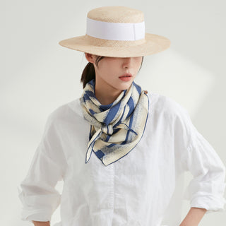 Elegant blue and white striped silk scarf styled around neck with straw boater hat and crisp white shirt, showcasing luxurious hand-rolled finish
