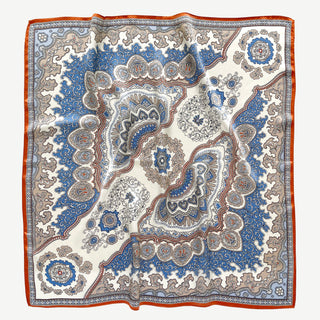 Luxury silk scarf with blue and orange baroque pattern featuring intricate paisley designs and medallions on cream background with vibrant border