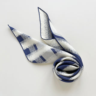 Triangle silk scarf with classic blue and white striped pattern, featuring hand-rolled edges and luxurious sand-washed finish, elegantly folded to display texture and drape.