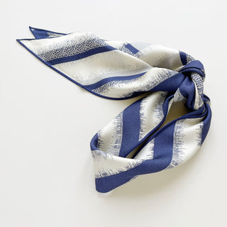 Triangle silk scarf with navy blue and white stripe pattern, displaying luxurious hand-rolled edges and sand-washed finish for elegant draping