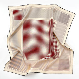 Luxury silk square scarf with red and white houndstooth center pattern, cream border with subtle stripes, and black hand-rolled edges