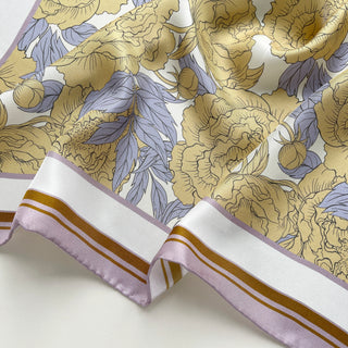 luxury silk scarf for women featuring light yellow peonies with lilac and ochre border, showing elegant drape and hand-rolled edges