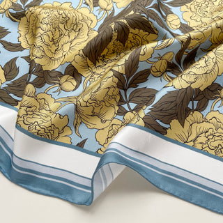 luxury silk scarf for women featuring light yellow peonies with dusty blue border, showing elegant drape and hand-rolled edges
