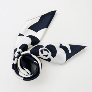 Elegant black and white silk scarf with camellia flower pattern, artfully draped to show the hand-rolled edges and luxurious twill texture