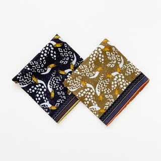 Amazon Toucan organic cotton-silk scarf in mustard ochre and midnight black, folded neatly on a white background.