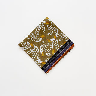 Amazon Toucan organic cotton-silk scarf in mustard ochre, folded neatly on a white background.