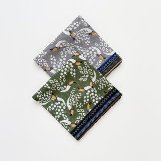 Amazon Toucan organic cotton-silk scarf in stone grey and green, folded neatly on a white background.