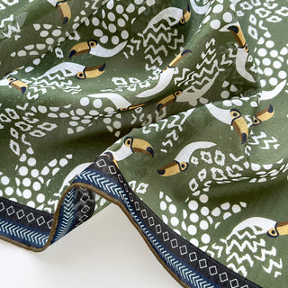 Organic cotton-silk scarf in green with toucan print and understated jacquard texture, featuring contrast border
