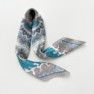 Elegant silk scarf with vintage baroque pattern in turquoise blue and taupe on cream background, featuring ornate medallions and decorative border