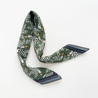 Organic cotton-silk scarf in green with toucan print and understated jacquard texture, featuring contrast border and hand-rolled edges