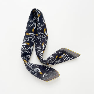 Organic cotton-silk scarf in black with toucan print and understated jacquard texture, featuring contrast border and hand-rolled edges