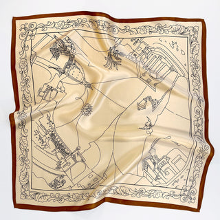 Square beige silk scarf with brown border featuring illustrated city landmarks and decorative floral edges, showcasing luxurious sheen and elegant design
