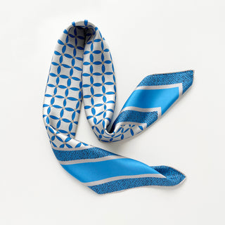 90x90cm silk scarf with geometric blue petal print and striped border on a light grey base, hand-rolled edges, made of double-sided printed silk twill.