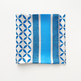 Folded 90x90cm silk scarf with geometric blue petal print and striped border, hand-rolled edges, made of double-sided printed silk twill.