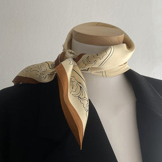 53x53cm silk bandana for women featuring a beige base with intricate black architectural illustrations and a brown border. This elegant women's silk scarf adds a touch of luxury and sophistication to any outfit.