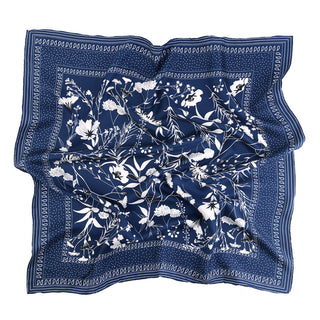 Square navy blue silk scarf with delicate white floral pattern and hand-rolled edges, featuring elegant botanical designs bordered by dotted trim