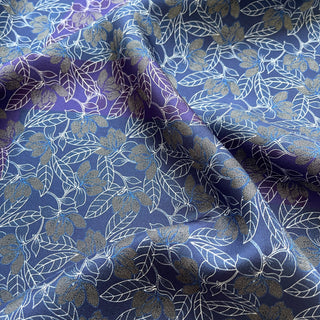Close up of a men’s silk neckerchief scarf 53cm, double-sided blue and purple floral print with hand-rolled edges, luxury square accessory