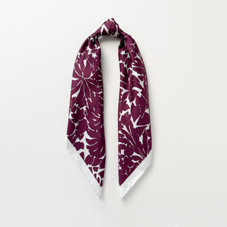 Luxury silk scarf in burgundy floral print with ice white border on a light grey background.