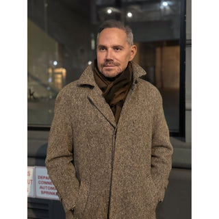 Man wearing a brown and black cashmere scarf by LuluLane in camel coat showcasing a sharp and refined look.