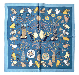 Dusty blue silk bandana scarf with mystical tarot garden design featuring illustrated hands, palms, celestial symbols, and botanical elements arranged in a symmetrical pattern