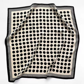 Square silk scarf with cream background featuring black polka dots and a border of black and white stripes, displayed flat with gentle folds