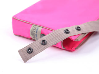 Bright pink recycled crossbody bag with beige strap featuring metal snap buttons and Urban Walk brand tag, showcasing sustainable RPET material