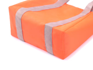 Bright orange recycled large tote bag with gray handles and trim, showing structured bottom and neat piping detail, made from water-resistant RPET fabric