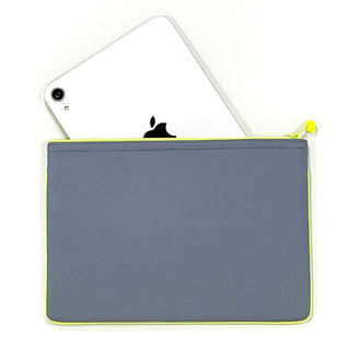 Gray recycled waterproof iPad case with neon yellow zipper trim, partially showing a white iPad inside against white background
