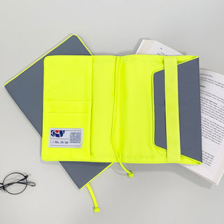 Eco-friendly recycled notebook cover in bright neon yellow with gray exterior, showing interior compartments for tablets and books, displayed open with book inside