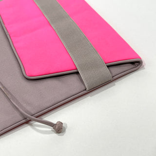 Eco-friendly recycled notebook cover in bright pink and gray fabric with elastic closure band and piping detail, designed for tablets and organizers