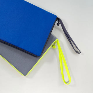 Eco-friendly recycled Kindle cases in vibrant blue and gray with neon yellow and navy zipper pulls and wrist straps against white background.
