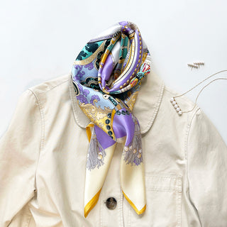 Luxurious silk scarf in yellow and lilac with ornate vintage pattern, elegantly styled on cream coat with yellow border and decorative tassels