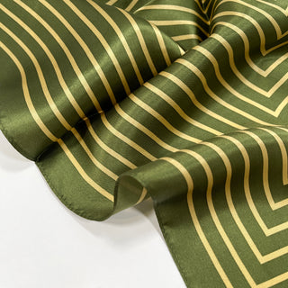 Moss green silk scarf with gold geometric stripe pattern, showing the luxurious sheen and soft folds of the fabric bandana.
